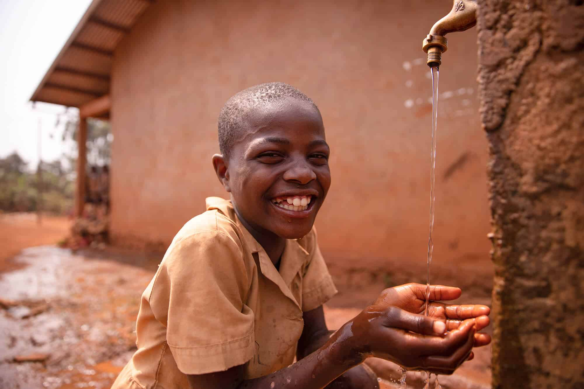smiling-black-african-schoolboy-drinking-from-a-ta-2023-11-27-04-55-06-utc.jpg